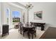 Formal dining room with large windows, chandelier, and an elegant dark wood dining set at 28451 Great Bend Pl, Wesley Chapel, FL 33543