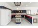 Open kitchen featuring a tiled island, white appliances, and unique dark blue cabinetry at 28451 Great Bend Pl, Wesley Chapel, FL 33543