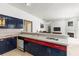 Bright kitchen features tiled countertops, colorful cabinets, and seamlessly connects to the living area at 28451 Great Bend Pl, Wesley Chapel, FL 33543