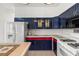 Kitchen showcasing stainless steel refrigerator and tile countertops with custom blue cabinets at 28451 Great Bend Pl, Wesley Chapel, FL 33543