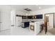 Spacious kitchen with tiled island and breakfast bar, white appliances and contrasting cabinetry at 28451 Great Bend Pl, Wesley Chapel, FL 33543