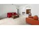 Comfortable living room with neutral carpet, a bright red sofa, and stylish decorative accents at 28451 Great Bend Pl, Wesley Chapel, FL 33543