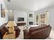 Cozy living room features comfortable leather seating, fireplace and sliding glass doors leading to pool at 28451 Great Bend Pl, Wesley Chapel, FL 33543
