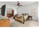 Bright bedroom with ceiling fan, adjacent home office, and large television at 28451 Great Bend Pl, Wesley Chapel, FL 33543
