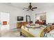 Sunlit bedroom featuring a dresser, full length mirror, and view to adjacent study at 28451 Great Bend Pl, Wesley Chapel, FL 33543