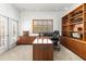 Home office with large built-in shelves, wood shutters, and french door to patio at 28451 Great Bend Pl, Wesley Chapel, FL 33543