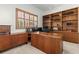 Home office featuring a large built-in bookcase, wood shutters, and executive desk at 28451 Great Bend Pl, Wesley Chapel, FL 33543