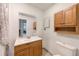 Bright bathroom featuring a vanity with a white countertop, mirror, and wooden cabinets for storage at 2933 Bough Ave # C, Clearwater, FL 33760