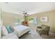 Comfortable bedroom with a ceiling fan, two windows, and a cozy reading chair at 2933 Bough Ave # C, Clearwater, FL 33760
