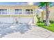 Exterior of townhome with a two-car garage, a second-floor balcony, and well-maintained landscaping at 2933 Bough Ave # C, Clearwater, FL 33760
