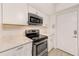 Kitchen with stainless steel appliances, white cabinetry, and overhead microwave oven at 2933 Bough Ave # C, Clearwater, FL 33760