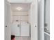 Laundry room featuring a white washer and dryer, shelving, and a louvered door at 2933 Bough Ave # C, Clearwater, FL 33760
