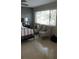 Neutral bedroom features neutral walls, a ceiling fan, tile floors, and a large window at 3062 Eastland Blvd # 105, Clearwater, FL 33761
