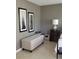 Neutral bedroom features tile floors, neutral walls, a storage bench, and large framed art at 3062 Eastland Blvd # 105, Clearwater, FL 33761