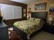 Inviting bedroom with a dark wood bed frame and colorful tropical-themed bedding at 3062 Eastland Blvd # 105, Clearwater, FL 33761