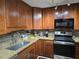 Traditional kitchen with wood cabinets, granite countertops, mosaic backsplash and stainless appliances at 3062 Eastland Blvd # 105, Clearwater, FL 33761