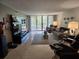 Open living room with tile flooring, sliding glass doors to the balcony and comfortable seating at 3062 Eastland Blvd # 105, Clearwater, FL 33761