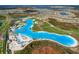 Breathtaking aerial view highlighting the community lagoon, residential areas, and vibrant green spaces at 30739 Penny Surf Loop, Wesley Chapel, FL 33545