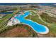Stunning aerial view of a community lagoon surrounded by neighborhood homes and lush landscaping at 30739 Penny Surf Loop, Wesley Chapel, FL 33545