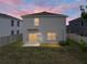 A spacious backyard at dusk, featuring a well-maintained lawn and a two-story house at 30739 Penny Surf Loop, Wesley Chapel, FL 33545