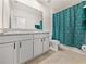 Bathroom featuring a double vanity, toilet, and a shower with a turquoise curtain at 30739 Penny Surf Loop, Wesley Chapel, FL 33545