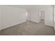 A neutral bedroom with plush carpet, large window and an open entryway to the rest of the upstairs at 30739 Penny Surf Loop, Wesley Chapel, FL 33545