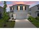 Charming two-story home featuring a well-manicured lawn, a two-car garage, and classic blue shutters at 30739 Penny Surf Loop, Wesley Chapel, FL 33545