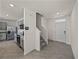 Open-concept entrance hall showcasing modern kitchen, staircase, and front door entrance for a welcoming arrival at 30739 Penny Surf Loop, Wesley Chapel, FL 33545