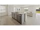 Kitchen with island open to the living room with stainless dishwasher and granite counters at 30739 Penny Surf Loop, Wesley Chapel, FL 33545