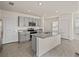 Stylish kitchen features a large island, granite counters, and gray cabinetry at 30739 Penny Surf Loop, Wesley Chapel, FL 33545
