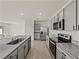 Bright kitchen with modern appliances, gray cabinets, and open layout to living room at 30739 Penny Surf Loop, Wesley Chapel, FL 33545