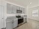Well-equipped kitchen shows gray cabinets, stainless appliances, and granite countertops at 30739 Penny Surf Loop, Wesley Chapel, FL 33545