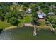 Stunning aerial view of lakeside property with lush landscaping, private dock, and circular pool in the backyard at 3113 W Sligh Ave, Tampa, FL 33614