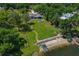 An aerial view of a beautiful lakefront property showing the private boat lift, beach, and circular pool at 3113 W Sligh Ave, Tampa, FL 33614