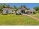 Expansive backyard with lush green grass, leading to a charming white home and carport at 3113 W Sligh Ave, Tampa, FL 33614