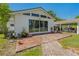Backyard patio with brick pavers, potted plants, and a view of the house's exterior and carport at 3113 W Sligh Ave, Tampa, FL 33614