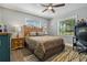Bedroom featuring a bed, side table, desk, chair, ceiling fan, and windows allowing natural light in at 3113 W Sligh Ave, Tampa, FL 33614