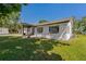 Charming home with well-maintained lawn, classic shutters, and white exterior under a sunny sky at 3113 W Sligh Ave, Tampa, FL 33614