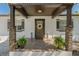 Inviting front porch with stone pillars, wooden door, potted plants, and stylish decor at 3113 W Sligh Ave, Tampa, FL 33614