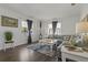 Bright living room features a large gray sectional sofa, neutral walls, and dark flooring at 3113 W Sligh Ave, Tampa, FL 33614