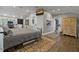 Bright bedroom with a large TV, neutral paint, wood floors and an adjacent doorway to a kitchen space at 3113 W Sligh Ave, Tampa, FL 33614