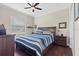 Comfortable bedroom featuring hardwood floors, a ceiling fan, and a large window at 31382 Chesapeake Bay Dr, Wesley Chapel, FL 33543