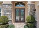 Close-up of the beautiful stone pillars and glass front doors with decorative trim at 31382 Chesapeake Bay Dr, Wesley Chapel, FL 33543