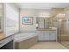 Bright main bathroom with garden tub, walk-in shower, and dual vanity sinks at 31382 Chesapeake Bay Dr, Wesley Chapel, FL 33543