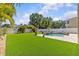 A large backyard features a well-manicured lawn with landscaping and a beautiful swimming pool with paver patio at 314 Crosswinds Dr, Palm Harbor, FL 34683
