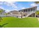 A large backyard features a well-manicured lawn with landscaping and a beautiful swimming pool with paver patio at 314 Crosswinds Dr, Palm Harbor, FL 34683
