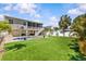 A large backyard features a well-manicured lawn with landscaping and a beautiful swimming pool with paver patio at 314 Crosswinds Dr, Palm Harbor, FL 34683