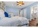 Comfortable bedroom with blue walls, hardwood floors, a ceiling fan, and an ensuite bath at 314 Crosswinds Dr, Palm Harbor, FL 34683