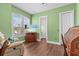Bedroom with green walls, wood floors, window, and an antique desk at 314 Crosswinds Dr, Palm Harbor, FL 34683