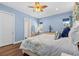 Comfortable bedroom with blue walls, hardwood floors, a ceiling fan, and lots of natural light at 314 Crosswinds Dr, Palm Harbor, FL 34683